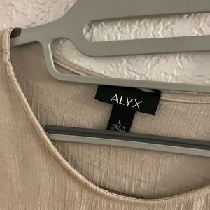 Alyx tan blouse, sheer material, with decorative ruffled sleeves. Size L